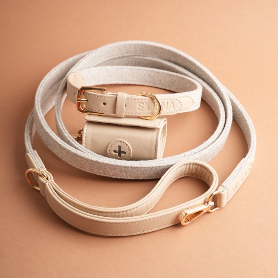 Beiges Hundeset von Siliena bestehend aus Leine, Halsband und Kotbeutelhalter stilvoll arrangiert auf warmem Hintergrund.